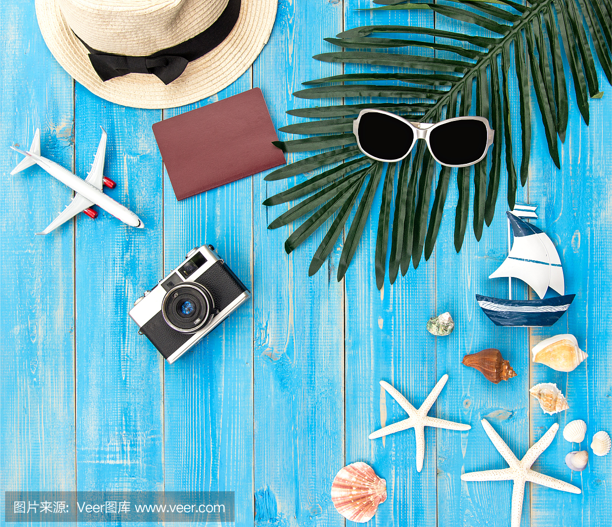 夏日时尚女士大帽子和配饰在沙滩上。热带海洋。不寻常的俯视图,色彩丰富的背景。夏天的概念。